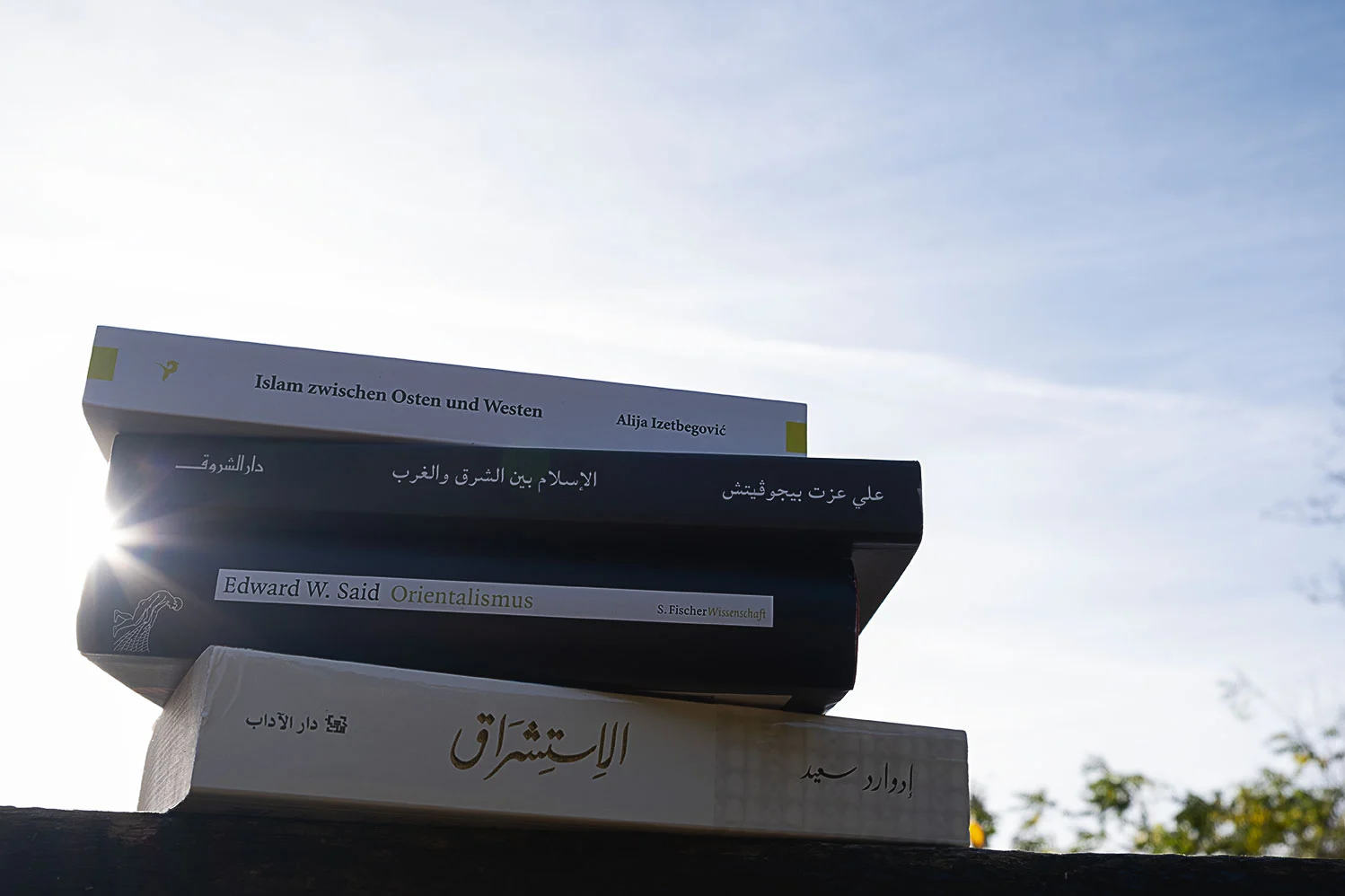 Vier Bücher liegen aufeinander. Oben befinden sich die deutschen und arabischen Ausgaben des Buches „Islam zwischen Ost und West“ von Alija Izetbegovic, darunter die deutschen und arabischen Ausgaben von „Orientalismus“ von Edward W. Said.